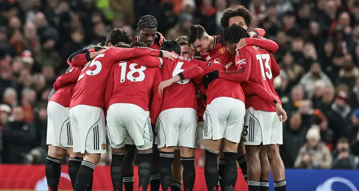 Piłkarze Manchesteru United w czerwonych strojach tworzą zwarty krąg, jednocząc się przed meczem. Ich wspólne united transfery budują ducha drużyny.
