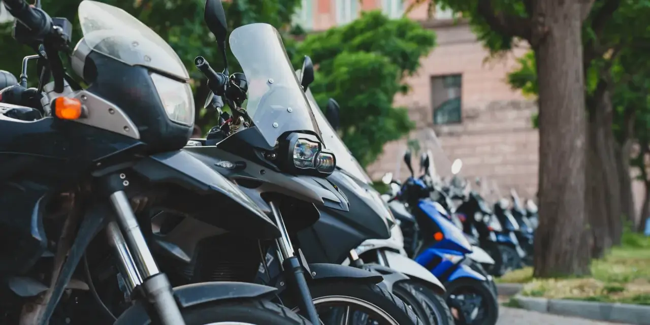 Różne rodzaje motocykli stojące w rzędzie, od turystycznych po sportowe.