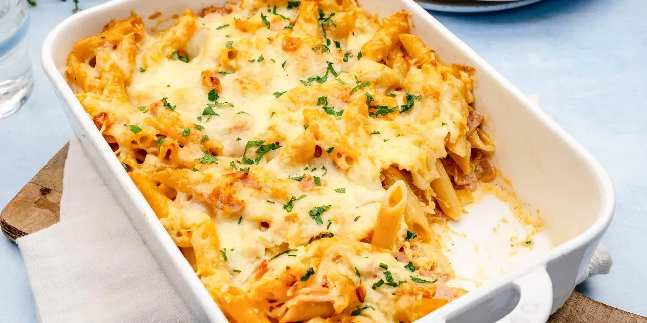 Herzhaftes Nudel Schinken Gratin mit geschmolzenem Käse und Petersilie, bereit zum Servieren.