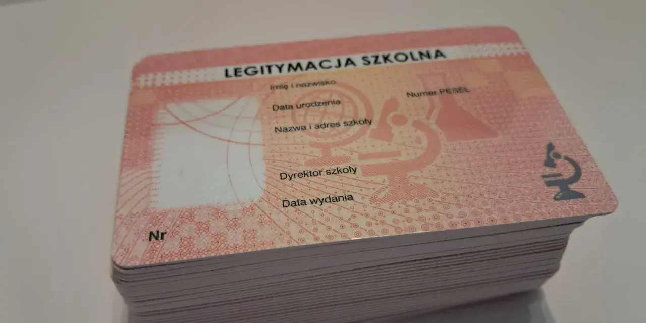 Stos nowych legitymacji szkolnych z miejscem na zdjęcie i danymi ucznia.