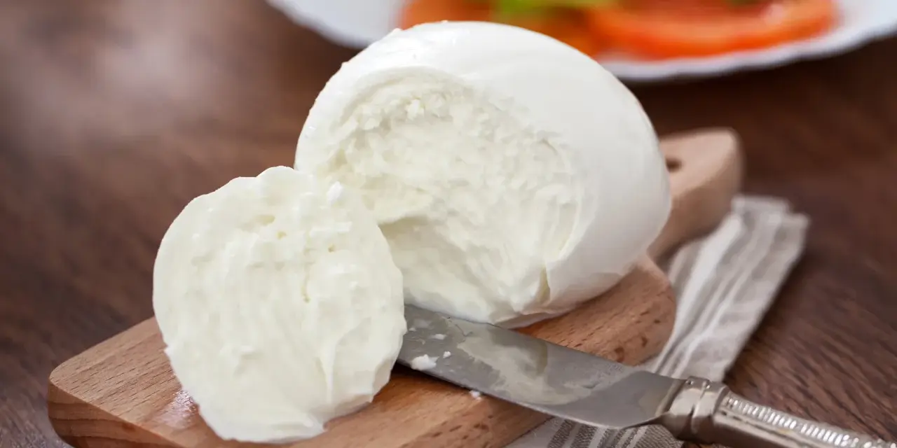 Świeża mozzarella na desce, gotowa do sałatki. Czy mozzarella jest wegetariańska? Tak, tradycyjnie tak!
