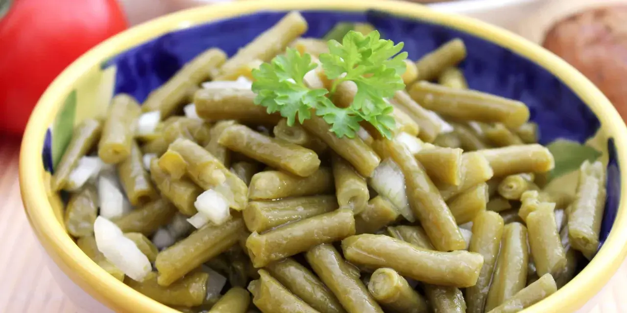 Bohnensalat rezept: Ein bunter Napf mit grünen Bohnen, Zwiebeln und Petersilie, bereit zum Servieren.