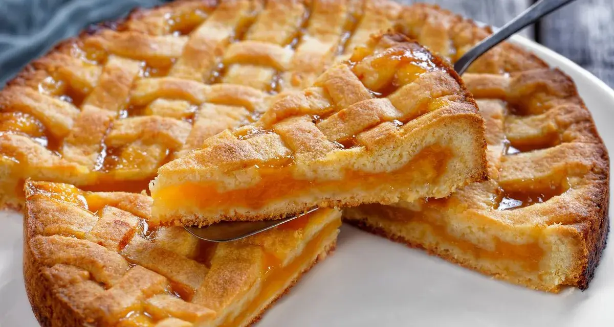 Deliziosa crostata senza glutine con ripieno di albicocche, la fetta sollevata mostra la morbidezza dell'impasto e la succosità della frutta.