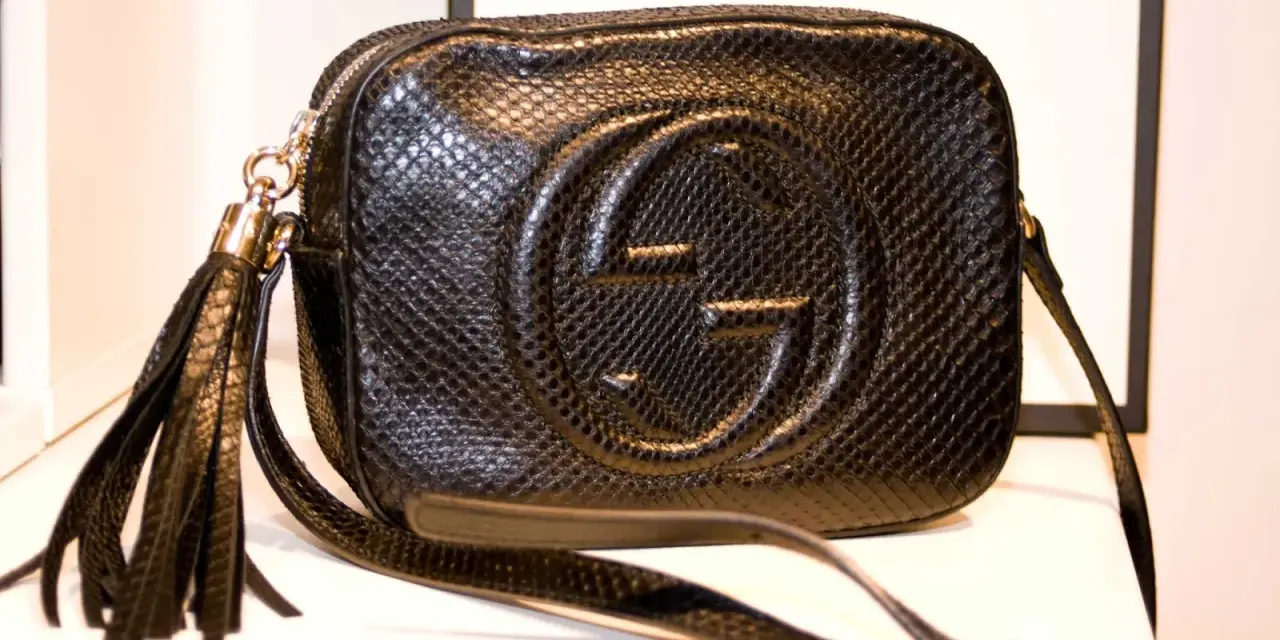 Czarna, pikowana torebka Gucci z wytłoczonym logo i frędzlami. Klasyczne, stylowe modele torebek Gucci.