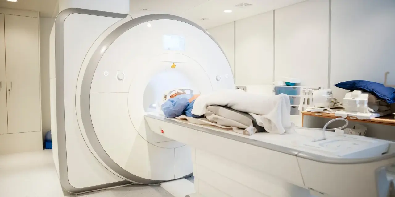 Pacjent leży na stole rezonansu magnetycznego, przygotowywany do badania kręgosłupa. Przepuklina kręgosłupa rezonans magnetyczny to klucz do diagnozy.