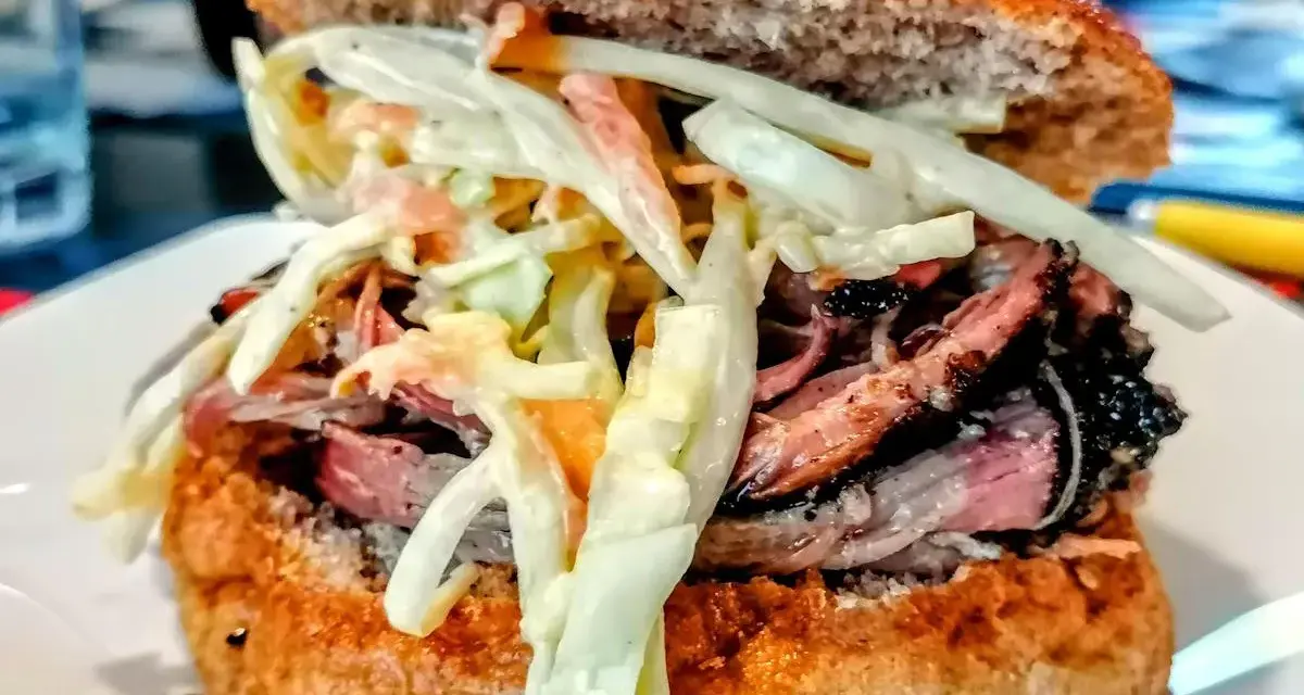 Sandwich con pulled pork, un classico della pulled pork ricetta, con pane integrale e insalata coleslaw cremosa.