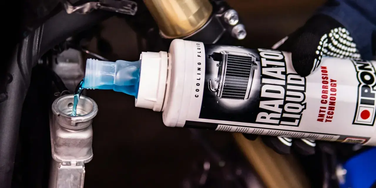 Versando liquido radiatore moto, uguale a quello per auto, nel serbatoio di raffreddamento.