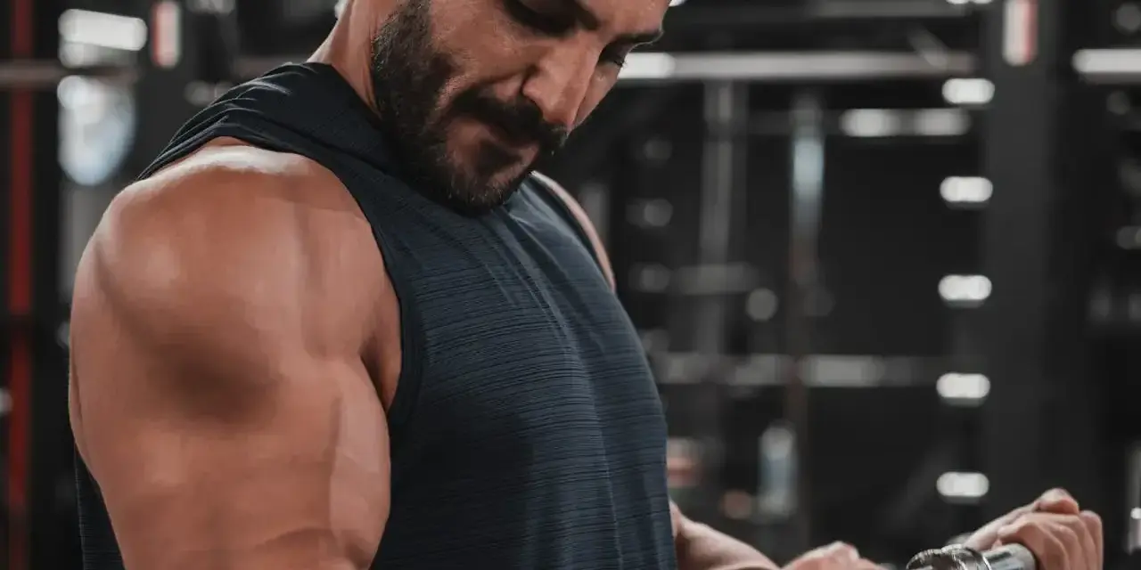 Mężczyzna ćwiczy biceps na siłowni. Zastanawia się nad cytrulina skutki uboczne, ale skupia się na treningu.
