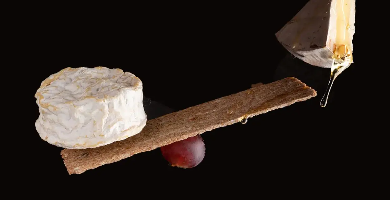 Queso camembert y brie, con galleta y uva. La diferencia entre camembert y brie se aprecia en sus formas y texturas.