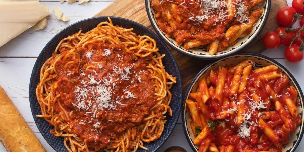 Pyszny obiad bez mięsa: spaghetti i penne w sosie pomidorowym, posypane parmezanem. Idealne dla wegetarian!