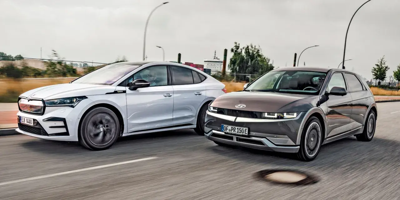 Dwa elektryczne samochody jadące obok siebie. Po prawej stronie ciemnoszary Hyundai Ioniq 5, po lewej biała Skoda. Zastanawiasz się nad ich zasięg?