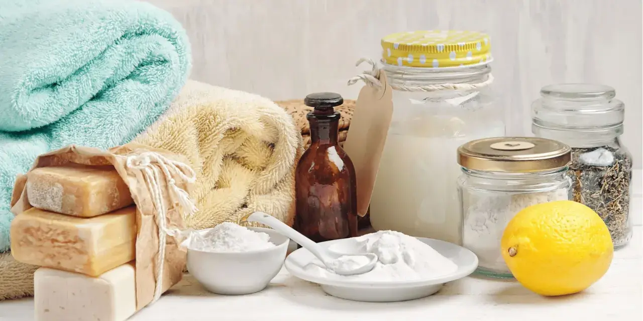 Ingrédients pour une recette lessive maison qui sent bon : savons, bicarbonate de soude, citron, herbes séchées.