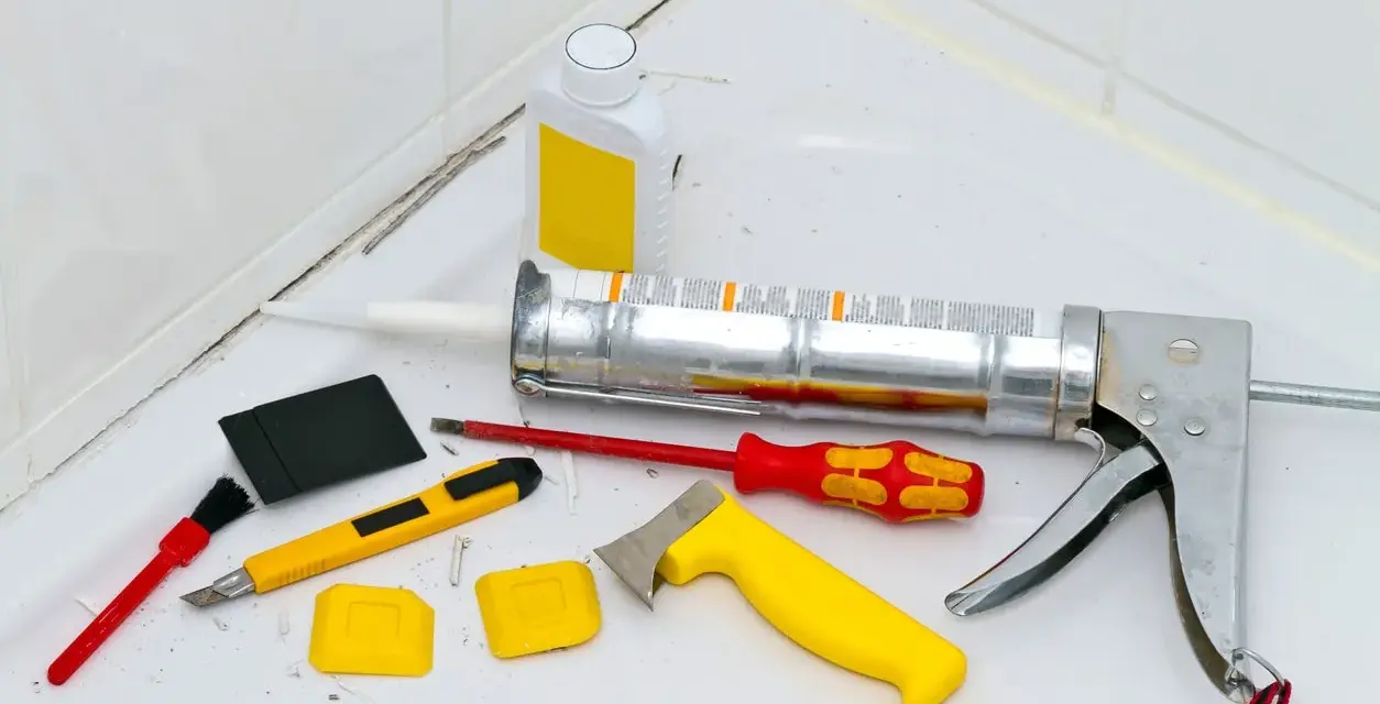 Attrezzi per la rimozione olio di silicone e sigillatura: pistola per silicone, taglierino, spatole, pennello e solvente.