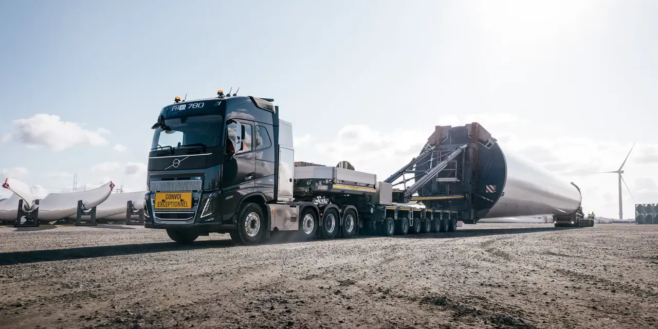 Potężny Volvo FH16 transportuje ogromną łopatę turbiny wiatrowej.