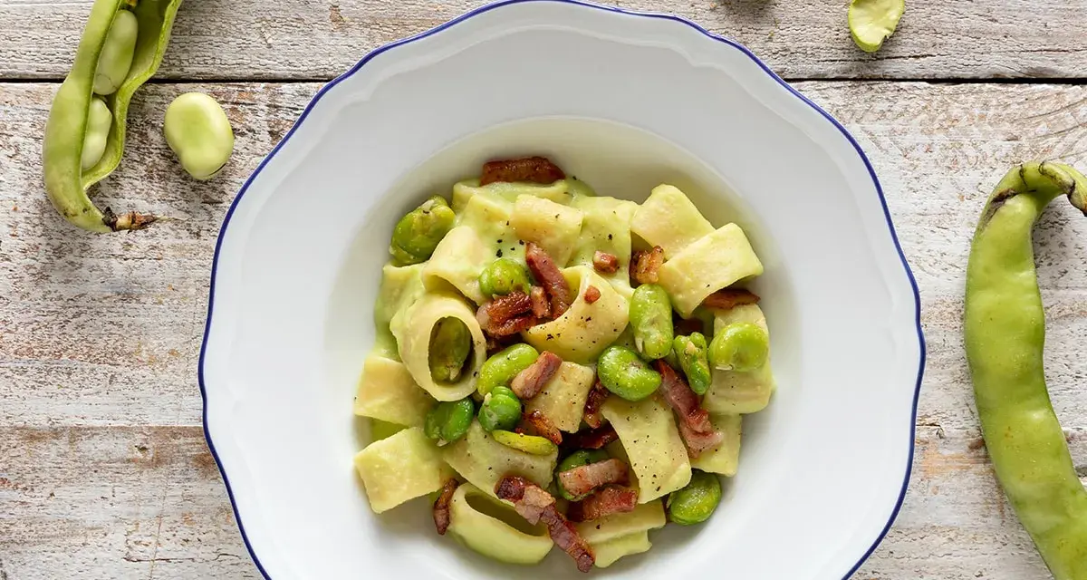 Piatto di pasta con fave fresche e croccante pancetta, un classico saporito.