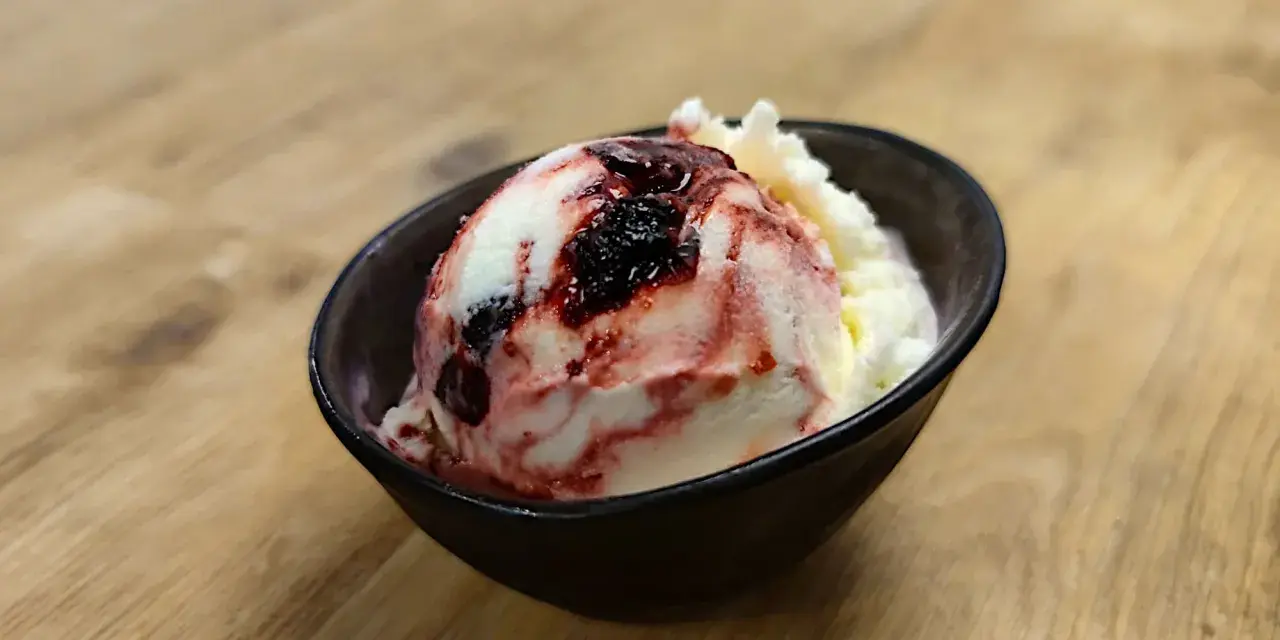 Ein Löffel cremiges Amarena Eis mit Kirschsauce und einem Hauch von Alkohol.