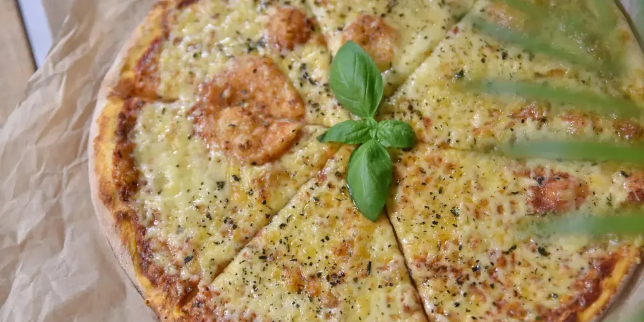 Pyszna pizza z serem i bazylią, idealne dodatki do pizzy.