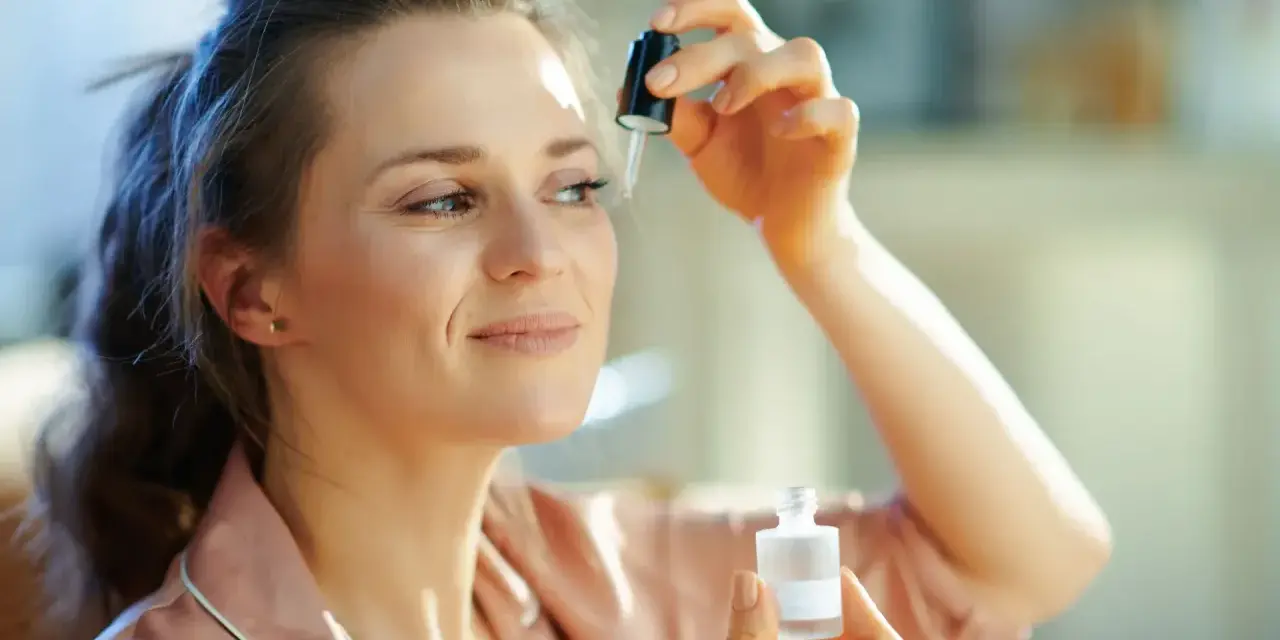 Kobieta aplikuje serum z **retinalem** na skórę pod okiem, dbając o młody wygląd.