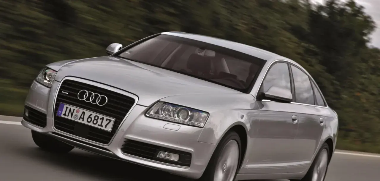 Silberner Audi A6 Limousine 2005 fährt auf einer Landstraße.