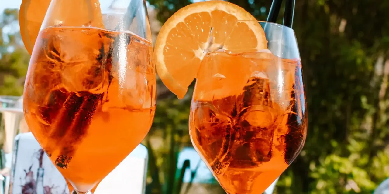 Dwa orzeźwiające drinki z pomarańczą i lodem, idealne na włoskie aperitivo.