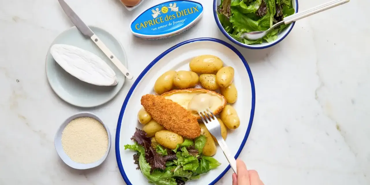 Délicieuse recette Caprice des Dieux pané, servi avec des pommes de terre et une salade verte. Le fromage coulant est irrésistible !
