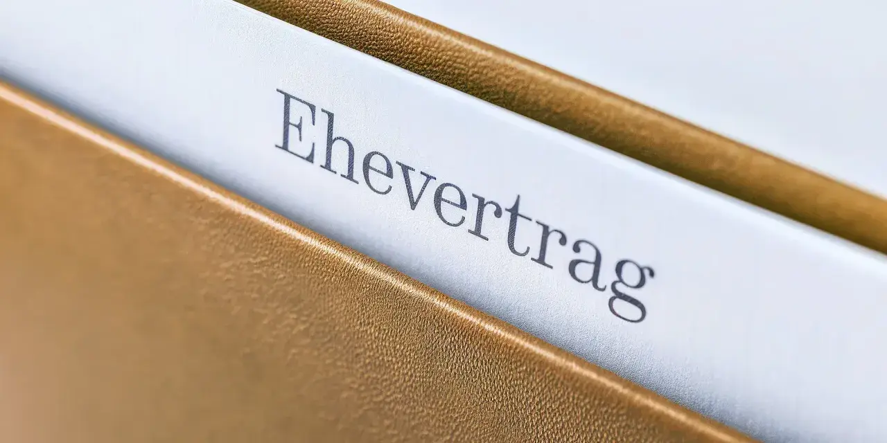 Ein Ehevertrag in einem braunen Ordner. Die Frage, ob man einen Ehevertrag aufheben ohne Notar kann, beschäftigt viele.