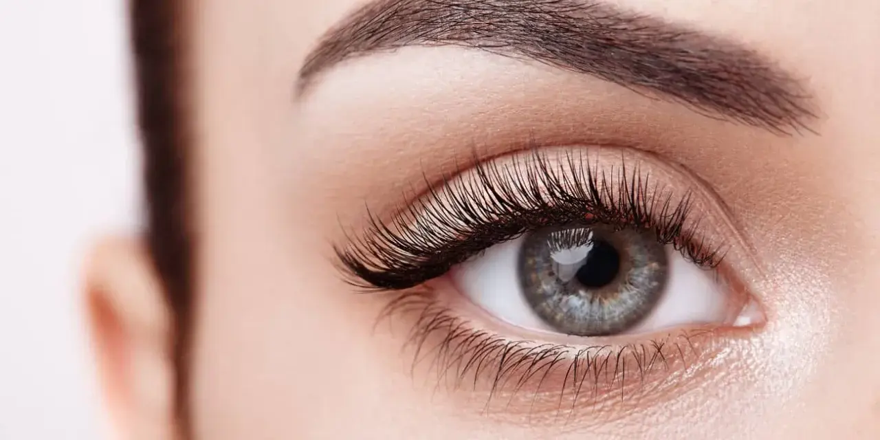 Ojo de mujer con pestañas largas y cejas definidas. Descubre cómo hacer crecer las pestañas para una mirada impactante.