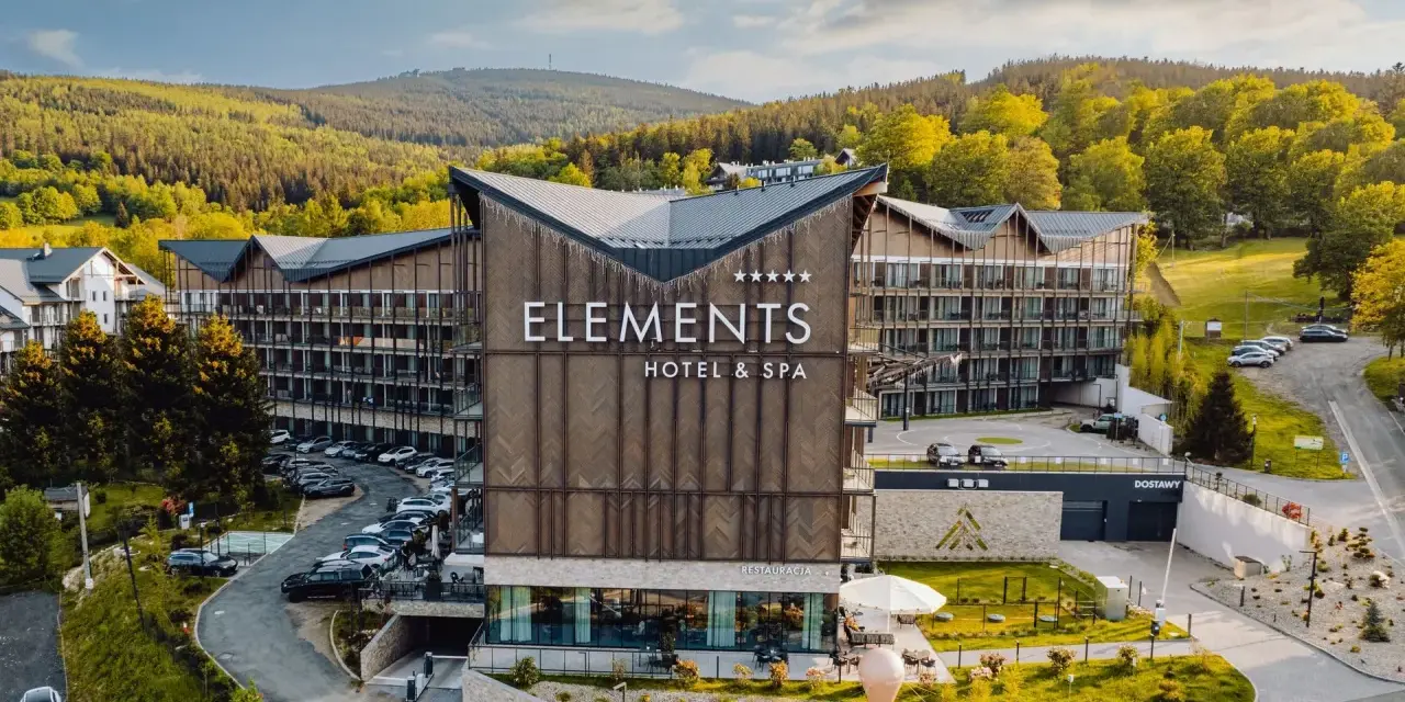 Nowoczesny hotel przy stoku narciarskim w Polsce, Elements Hotel & Spa, otoczony zielenią i górami. Idealne miejsce na zimowy wypoczynek.