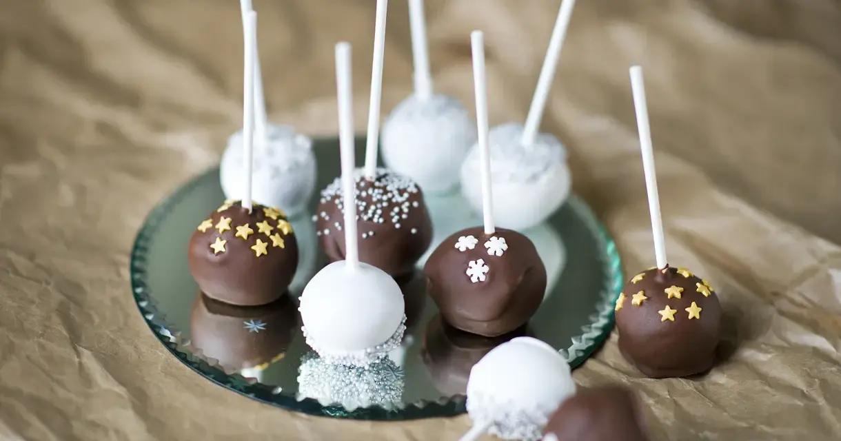 Läckra cakepops med choklad och vit glasyr, dekorerade med stjärnor och snöflingor. Ett enkelt cakepops recept att prova!