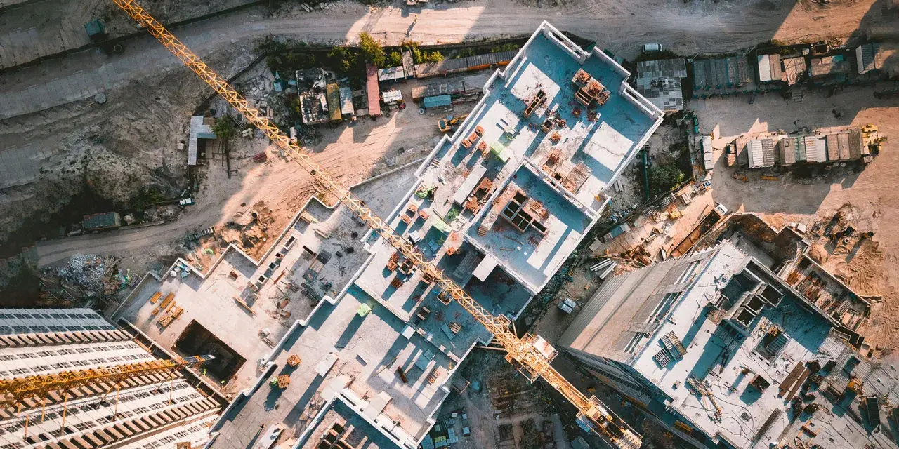 Aerial view of a construction site, showcasing the efficiency of drones in construction by providing an overhead perspective of building progress and material placement.