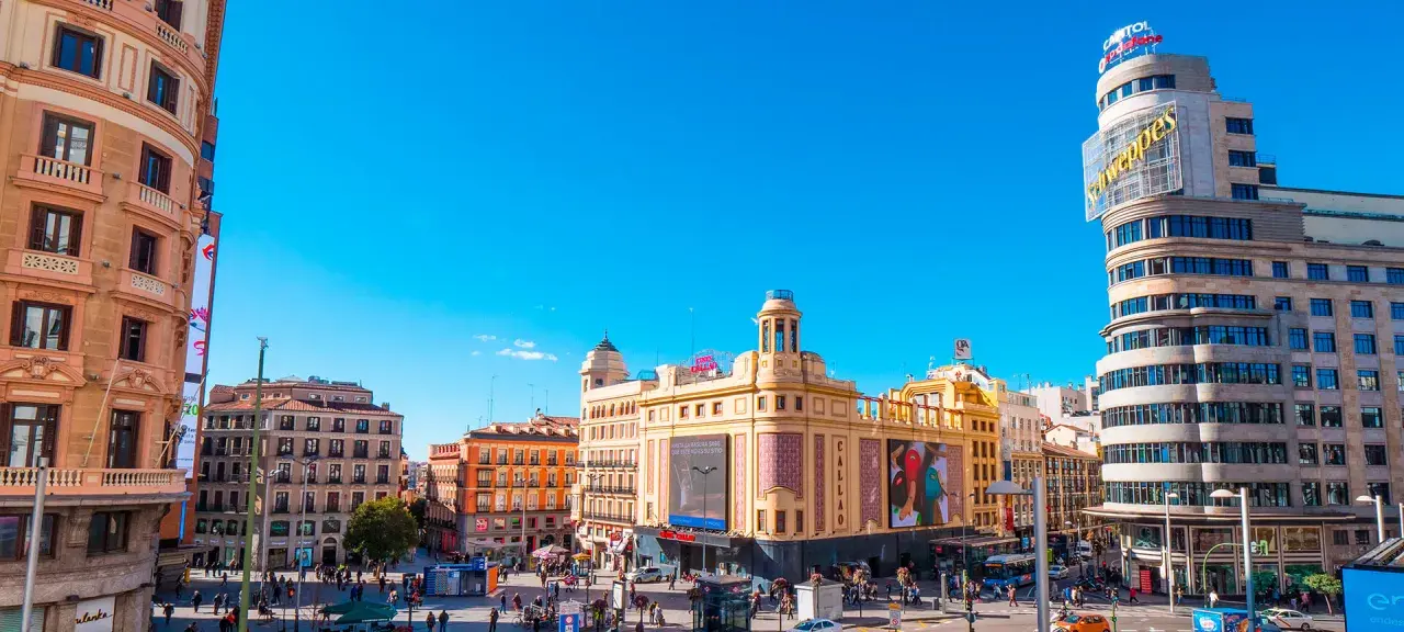 Tętniący życiem plac w Madrycie, idealny na jednodniową wycieczkę. Zobaczysz tu charakterystyczny budynek Capitol z neonem Schweppes i kino Callao.