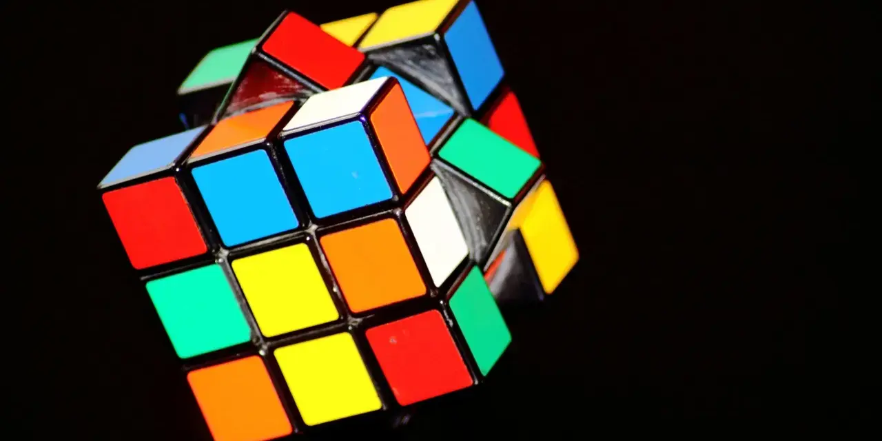 En färgglad rubiks kub 3x3 ligger på en mörk bakgrund.