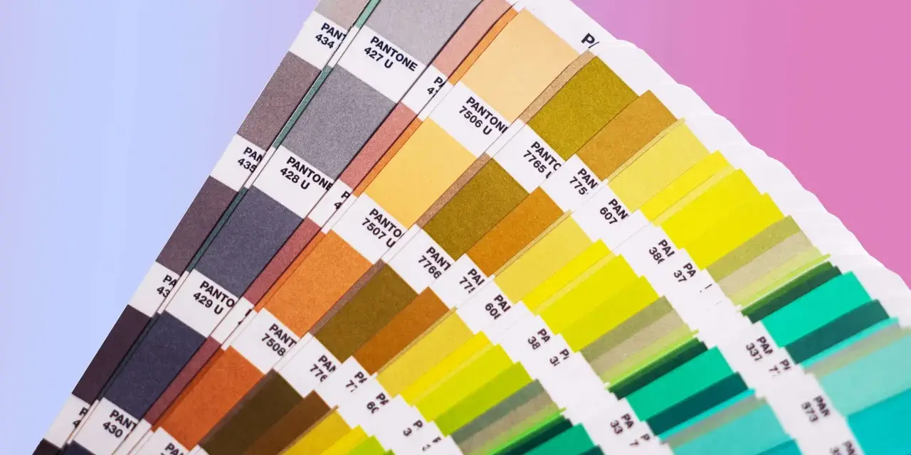 Próbnik kolorów Pantone, prezentujący bogactwo barw od brązów po zielenie i błękity, stanowi praktyczne narzędzie do zgłębiania teorii koloru.