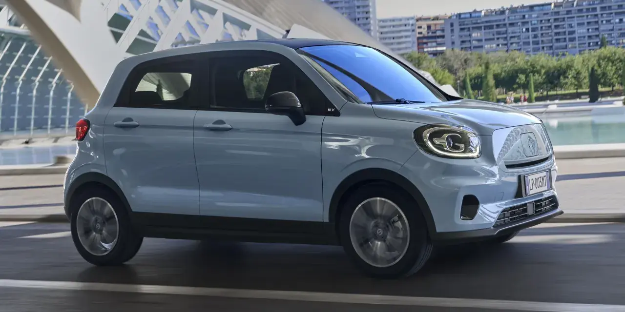 Jasnoszary Leapmotor T03 na tle nowoczesnej architektury. Sprawdź, jaka jest leapmotor t03 cena i czy to auto dla Ciebie.