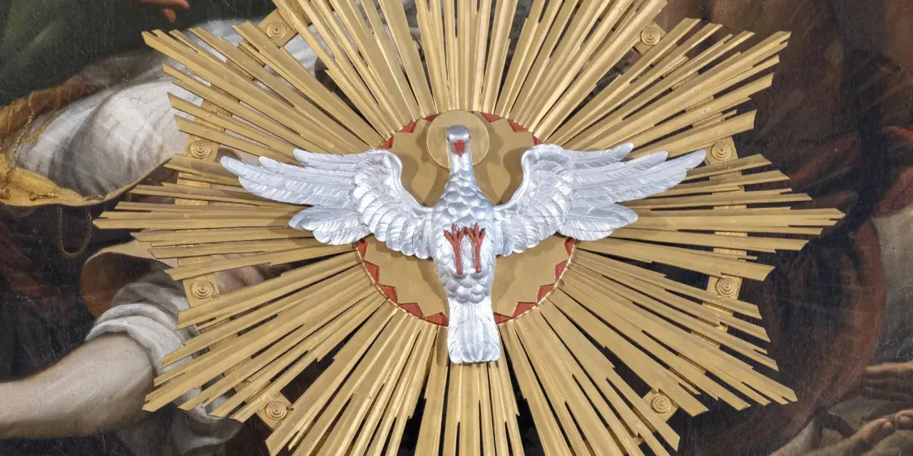 Ein silberner Taube mit ausgebreiteten Flügeln vor einem goldenen Strahlenkranz. Dies symbolisiert den Heiligen Geist und was bedeutet Pfingsten: die Ausgießung des Geistes.