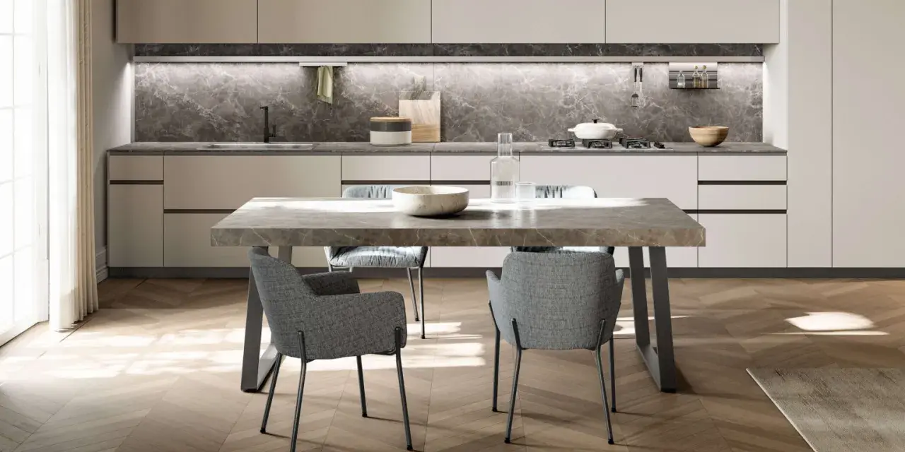 Tavolo 6 persone dimensioni perfette per cene conviviali. Design moderno con piano in marmo e sedie grigie imbottite.