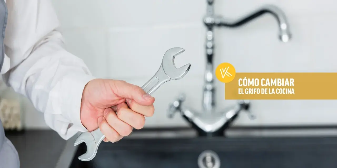 Mano con llave inglesa lista para instalar grifo cocina. Texto: "Cómo cambiar el grifo de la cocina".