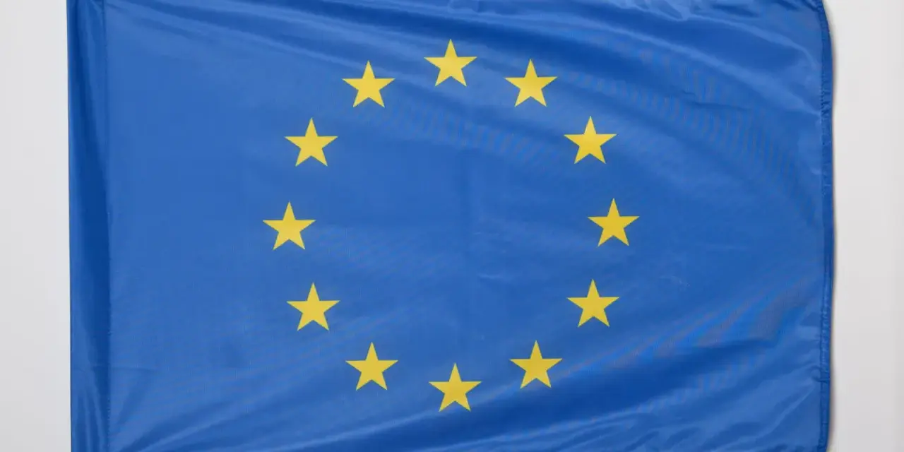 Flaga Unii Europejskiej, symbol jedności i współpracy, z dwunastoma złotymi gwiazdami na niebieskim tle.