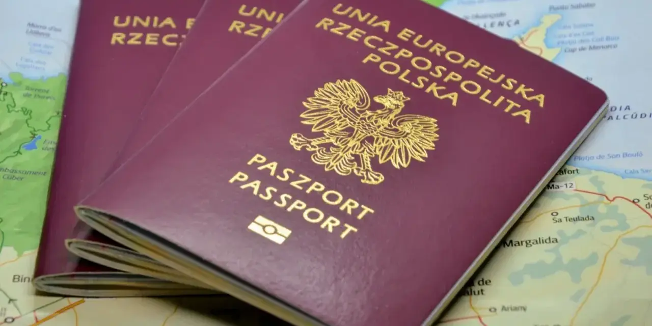 Trzy polskie paszporty leżą na mapie, gotowe do podróży. Opłata za paszport to niewielka cena za wolność odkrywania świata.