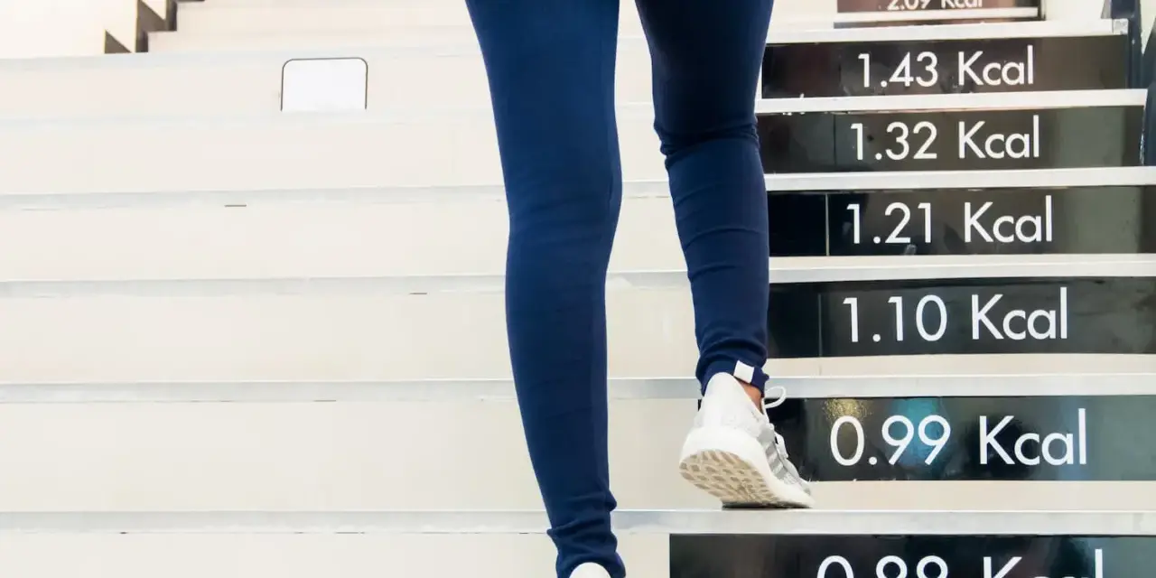 Personne montant des escaliers, chaque marche indiquant les calories brûlées. Une heure de marche pour brûler des calories.