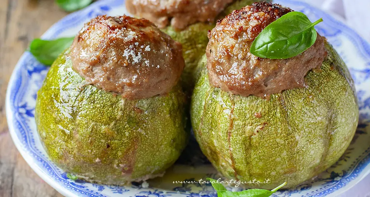 Zucchine tonde ripiene, un piatto gustoso del menù di Benedetta, servite su un piatto blu e bianco con basilico fresco.