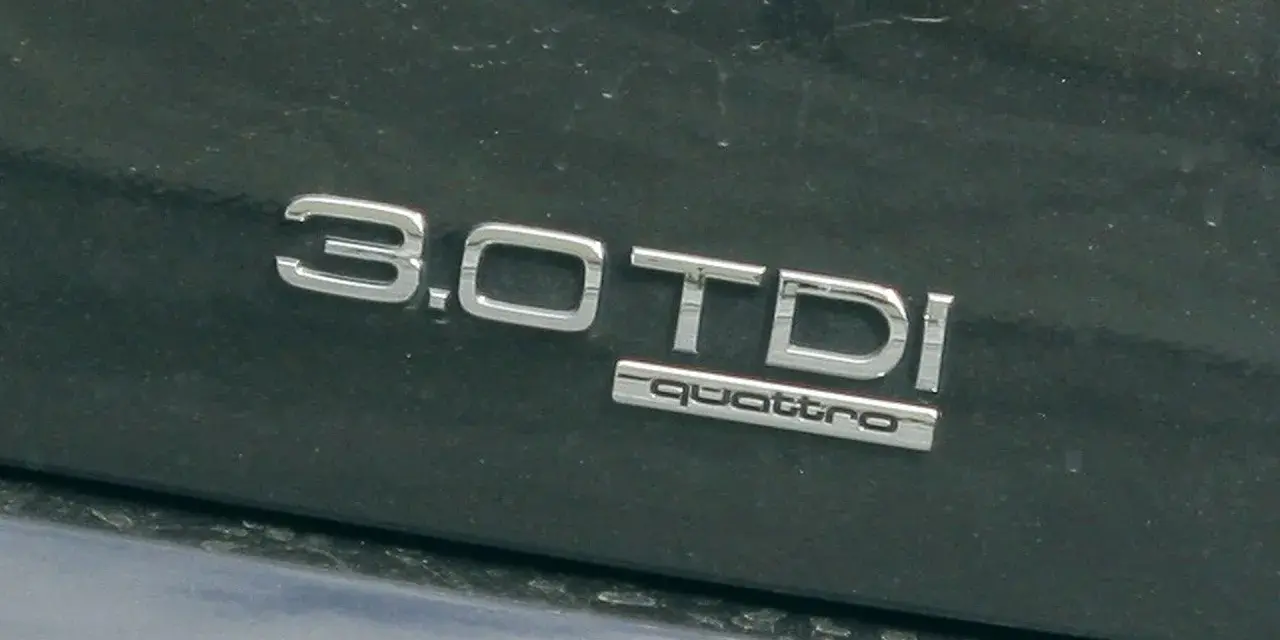 Napis "3.0 TDI quattro" na ciemnym lakierze. Ta pojemność silnika sugeruje moc i osiągi.