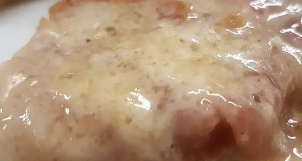 Cotoletta alla bolognese succulenta, con prosciutto e formaggio fuso, un classico della cucina emiliana.