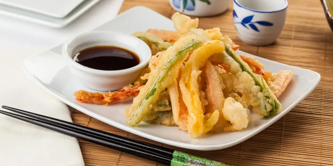 Crujiente tempura de verduras, con zanahoria, calabacín y pimiento, servida con salsa de soja.