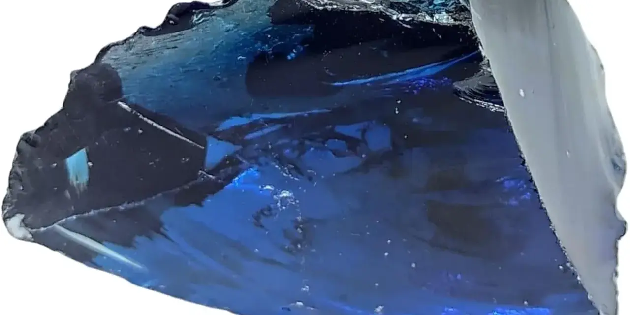 Fragmento de obsidiana azul con reflejos profundos y texturas irregulares, como un trozo de cielo nocturno solidificado.