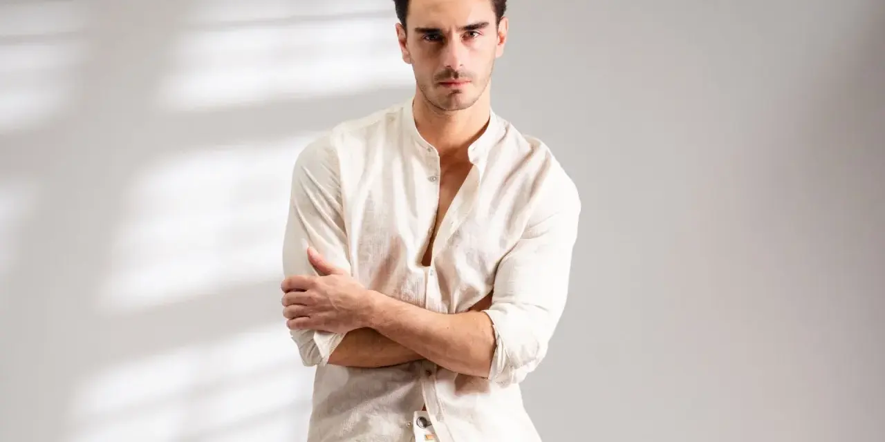 Uomo con outfit bianco e nero, camicia lino con colletto alla coreana e pantaloni chiari.