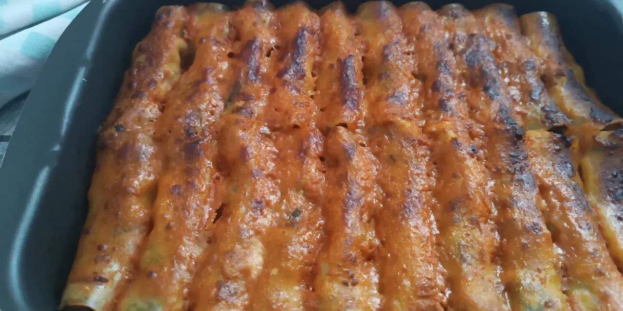 Cannelloni di carne ricetta della nonna, cotti al forno e ricoperti di sugo rosso e formaggio fuso.