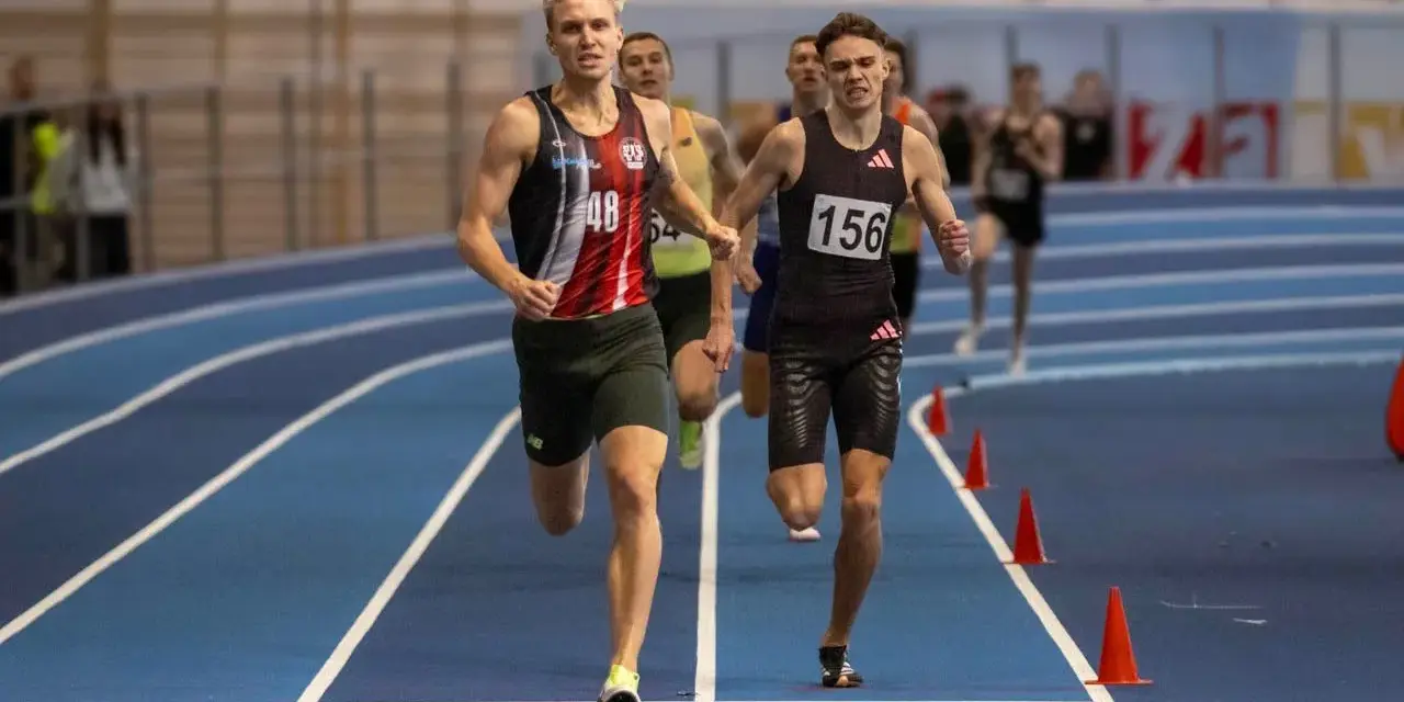 Filip Ostrowski biegnie w zawodach lekkoatletycznych. Dwóch zawodników na pierwszym planie, jeden z numerem 48, drugi z 156.