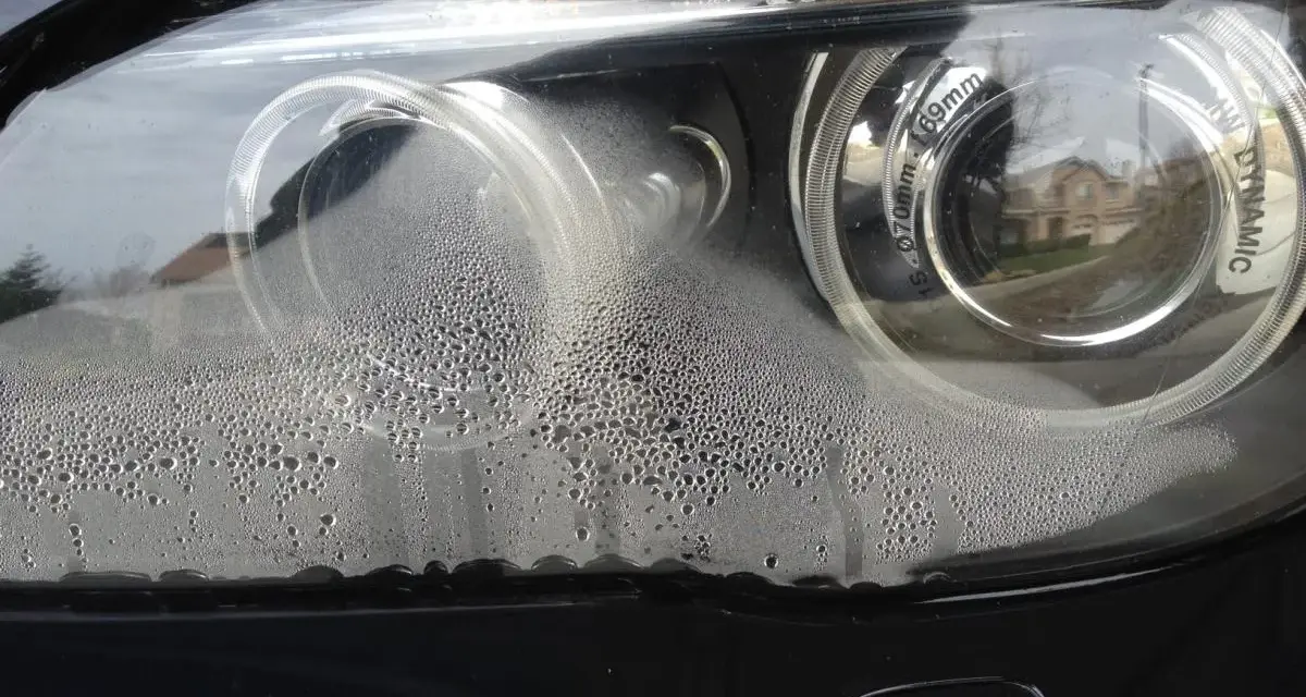 Krople wody wewnątrz reflektora BMW. Brak widocznych odpowietrzników w reflektorach sugeruje problem z uszczelnieniem.