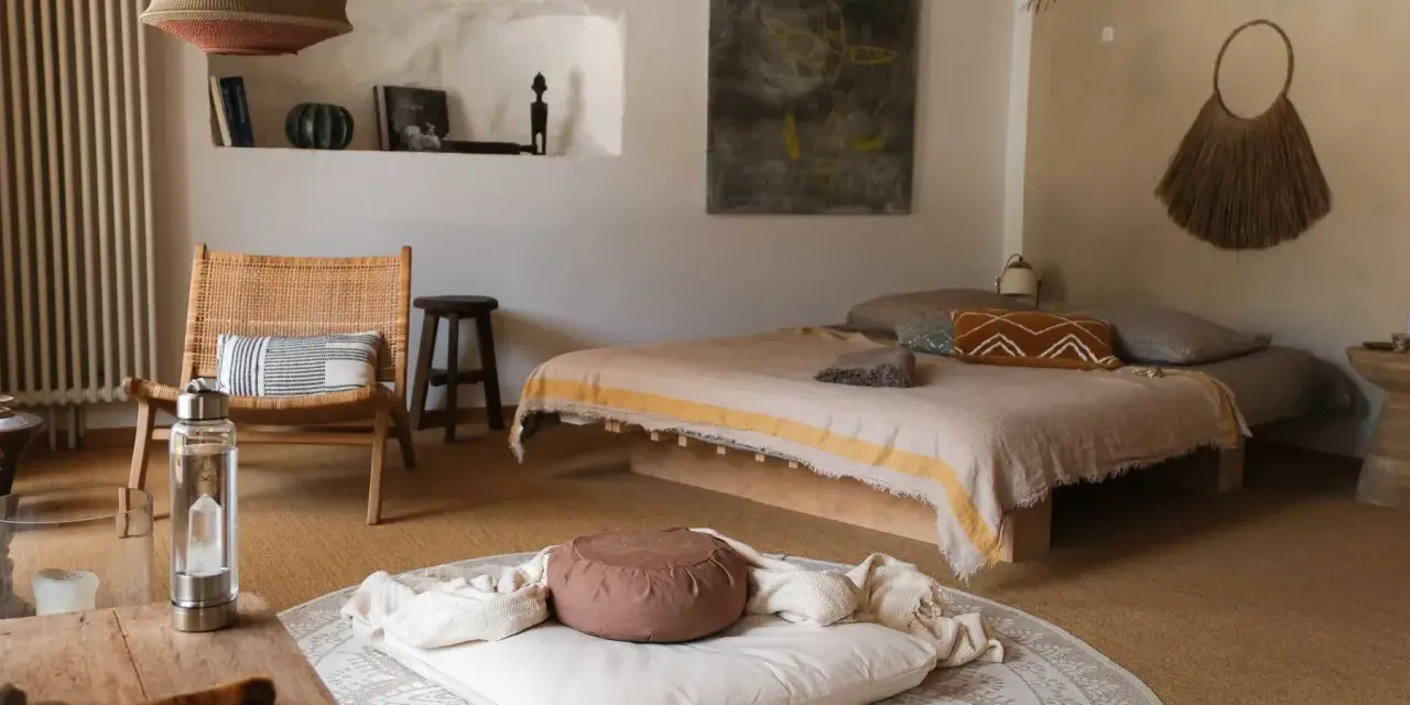 Ein gemütlicher Raum zum Meditieren einrichten: Ein Bett, ein Stuhl, Kissen und Decken laden zur Entspannung ein.